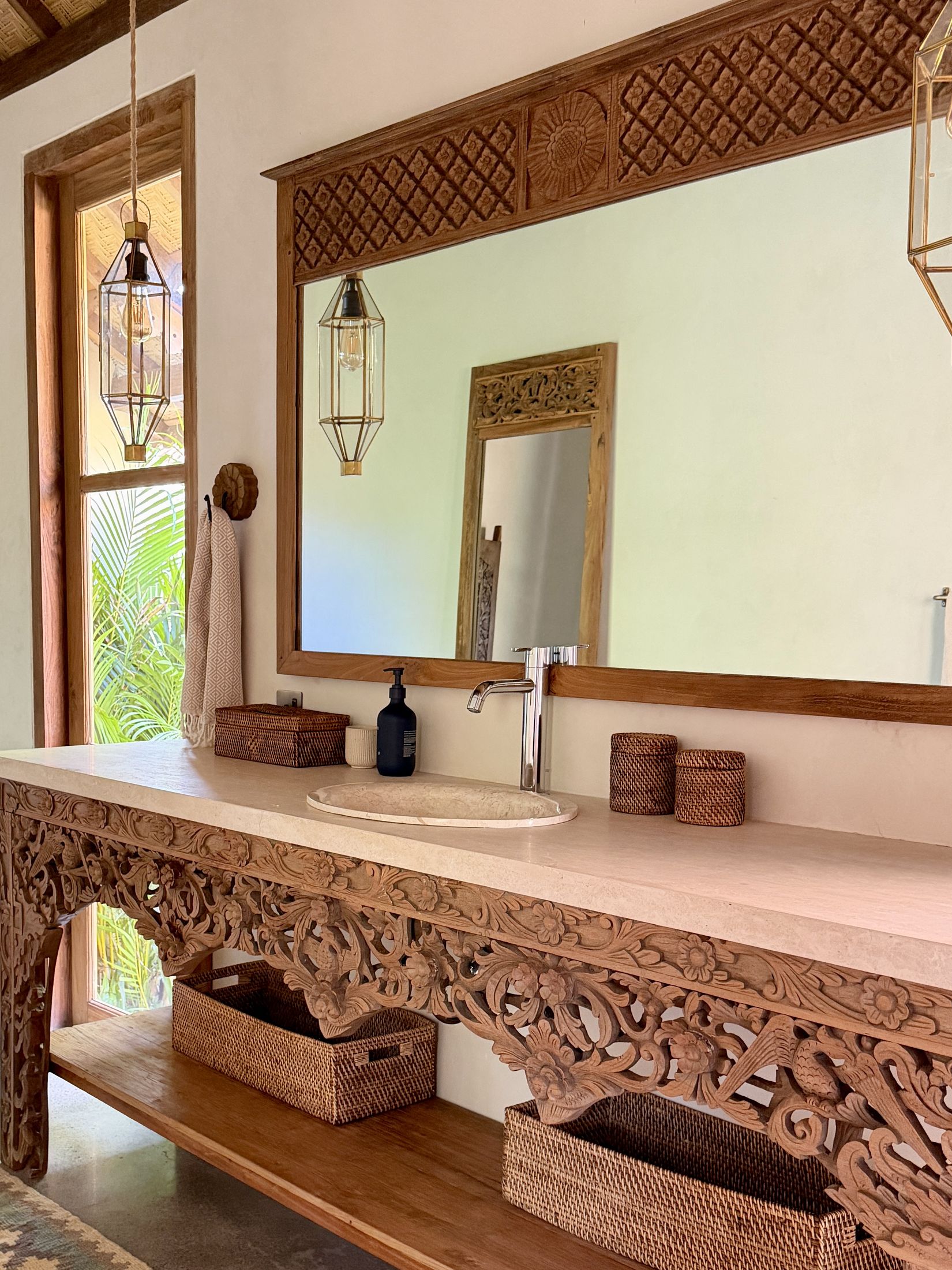 En suite bathroom vanity with carved mirror and stone sink